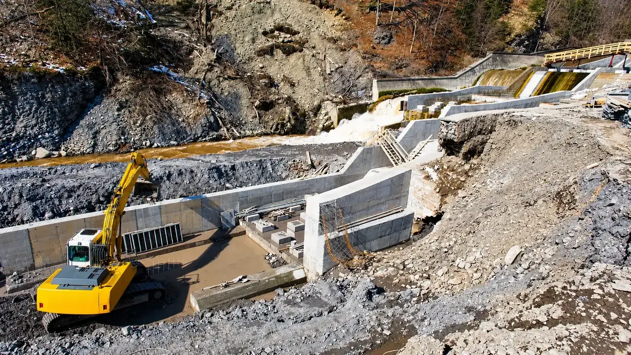 Excavator working at a dam spillway construction site